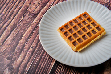 Chocolate & hazelnut flavour waffle from on a white plate.