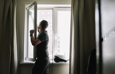 Man washing and cleaning window at home. Housework and housekeeping, home hygiene