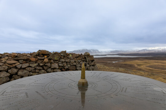 Sundial against the cloudy sky in Helgafell, Iceland
