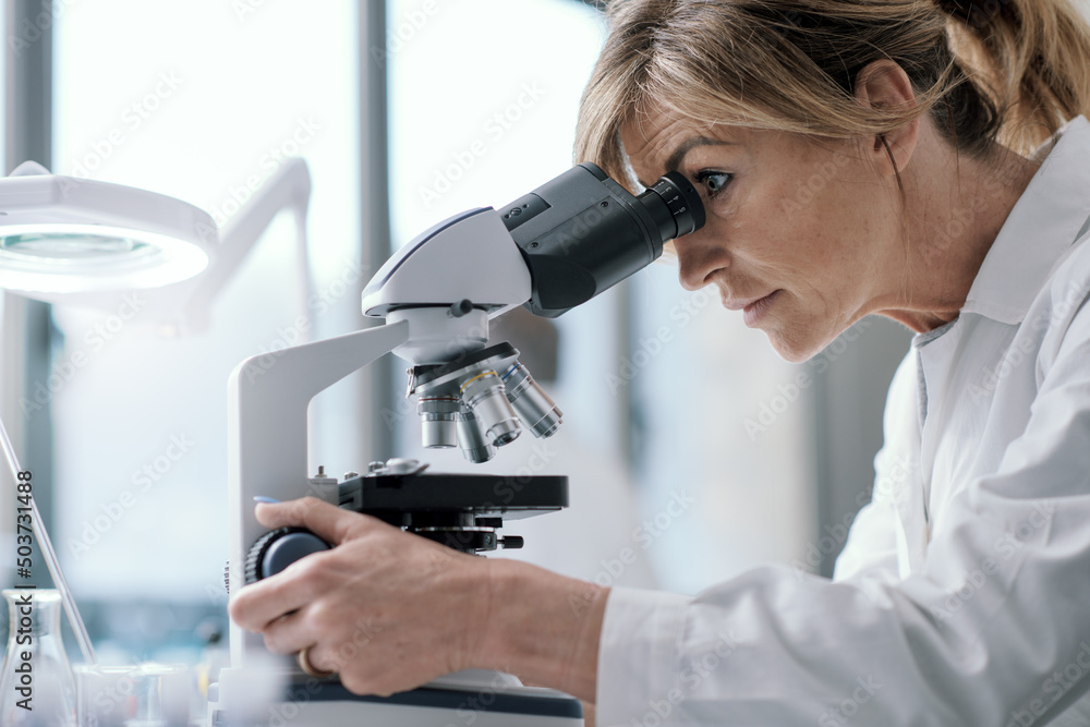 Wall mural professional scientist using a microscope