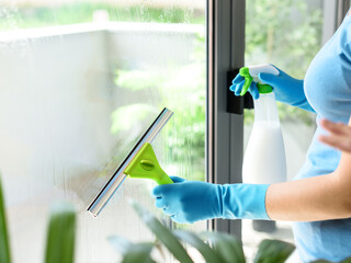 Woman washing windows at home