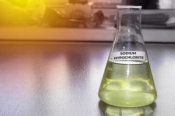 Sodium hypochlorite in glass flask. Formula NaClO. The concept of a chemical reagent for a product card on a website. High quality photo