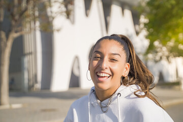 Portrait of a beautiful Arabic woman smiling and looking at camera outdoors in the student campus...