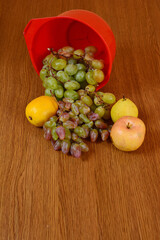 A ladle with autumn fruits overturned on the table.