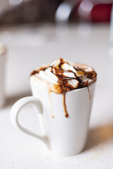 Delicious Cup of Mocha with whipped cream on a white table.