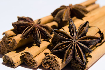 Stack of dry cinnamon wih star anise on white background