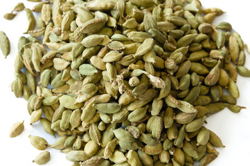 Heap of dry green cardamons on a white background
