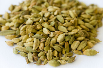 Heap of dry green cardamons on a white background