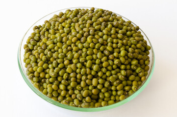 Mung beans in a glass bowl on a white background