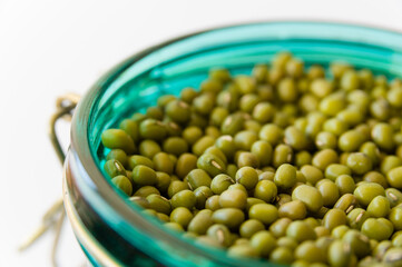 Mung beans in a glass jar on a white background