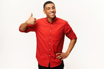 Cheerful African-American guy in red shirt showing thumb up isolated on white. Smiling multiracial...