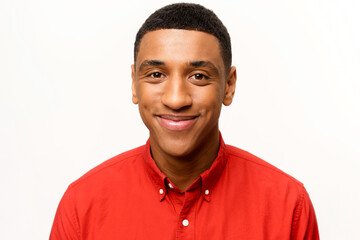 Headshot of friendly optimistic African-American guy in red shirt isolated on white. Smiling kind...