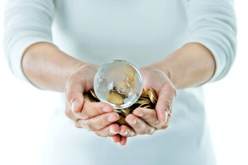 Crystal globe and coins in hands
