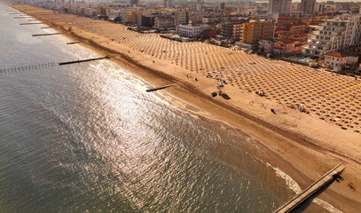 Jesolo - spiaggia con lettini  e ombrelloni in localit&agrave; estiva vista dall'alto con vista sulla citt&agrave;