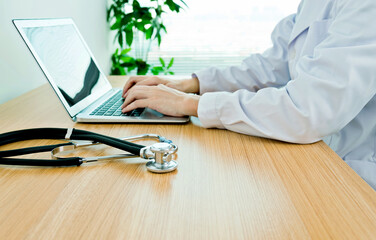 Doctor working with laptop in hospital office