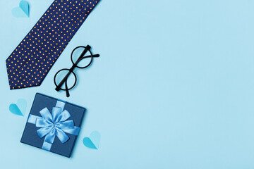 Father's Day. On a blue background tie glasses gift box.