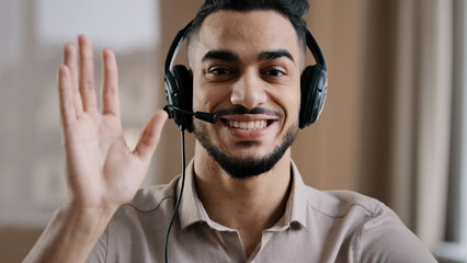 Smiling male operator hispanic businessman customer support service assistant representative greeting speak at web camera wear headset with microphone make video conference call remote job interview