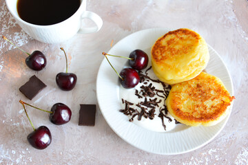 healthy breakfast with syrniki, fresh berries, yoghurt and cup of coffee
