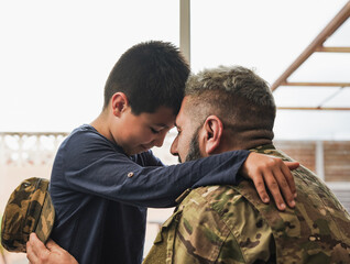 Military soldier man hugging his son at home - Father and child love