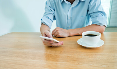 Man having a coffee and chatting with his mobile phone