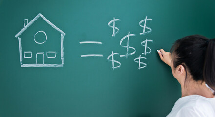 House figure and dollar symbols drawing chalk on blackboard