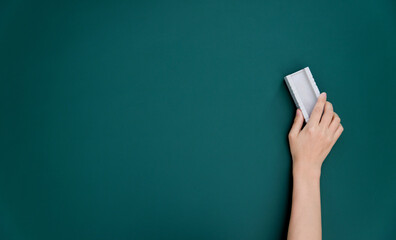 Hand holding brush erase on blackboard