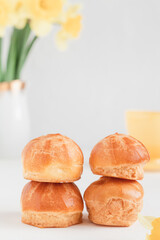 Mini vanilla eclairs on a blurred background. French breakfast.