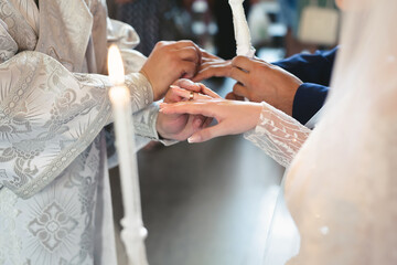 The priest consecrates the wedding rings on the fingers of the bride and groom. Wedding tradition and ritual. hands of a young couple in the church.