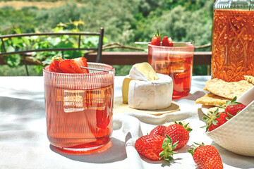 Cozy spring or summer breakfast or brunch outside on the table. Strawberry mocktail, camembert cheese, flat crispbread on linen tablecloth. Healthy snack. Picnic.