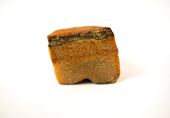 macro shooting raw specimen of tiger eye gemstone rock isolated on white background.