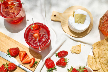 Cozy spring or summer breakfast or brunch outside on the table. Strawberry mocktail, camembert...