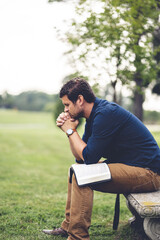 Caucasian male sitting and praying in the park