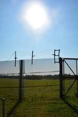 Old barbed wire fence on a former GDR border fortification with sun