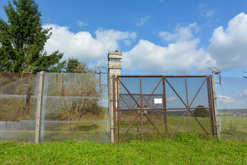 Old barbed wire fence with a watchtower on a former GDR border fortification