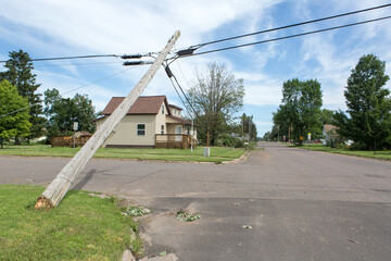 The storm caused severe damage to electric poles power lines over a road after Hurricane poles...