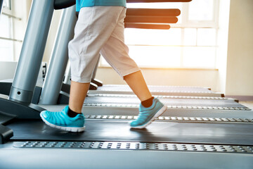 Young boy legs walking on treadmills in gym