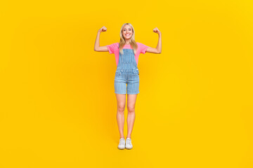 Full size portrait of satisfied glad lady arms fists show biceps isolated on yellow color background