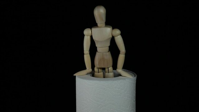 footage of toilet paper wooden figure dark background
