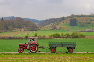Oldtimer vintage agricultural tractor towing a trailer