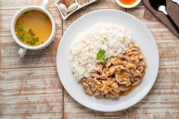 Stir-Fried Pork with Garlic and and pepper with cooked thai jasmine rice in white plate,popular Thai Street food.Top view