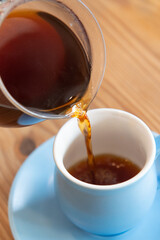 コーヒーポットでカップにコーヒーを注ぐ