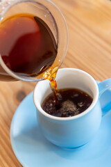 コーヒーポットでカップにコーヒーを注ぐ