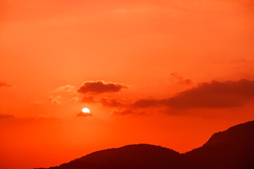 Great dramatic view. Amazing sky panorama. Meditative calmness and greatness. Red sun in the clouds. Colorful sunset in the evening sky. Clouds illuminated by the setting sun