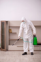 Young male contractor doing pest control at home