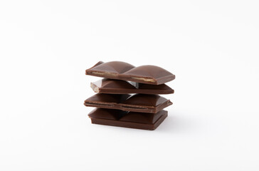 Slices of delicious milk chocolate isolated on white background. Chocolate bar. Sweets with cocoa butter.