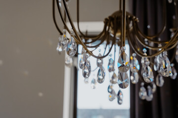 Noble and luxurious crystal chandelier light. Closeup crystal pendants of the chandelier, blur background, glamour background with copy space.