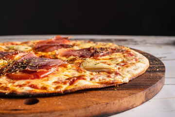 Delicious Spanish Iberian ham pizza on a wooden table