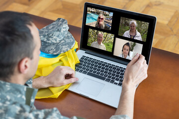 Happy soldier man smiling while making conference call on laptop indoors. ukraine