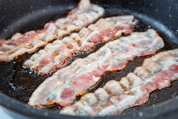 Crispy smokey fried bacon slice or strip. Unhealthy fat food, fattenig ingredient. Red Thin slice...