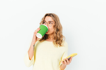 Cute blonde girl wearing glasses drinks coffee